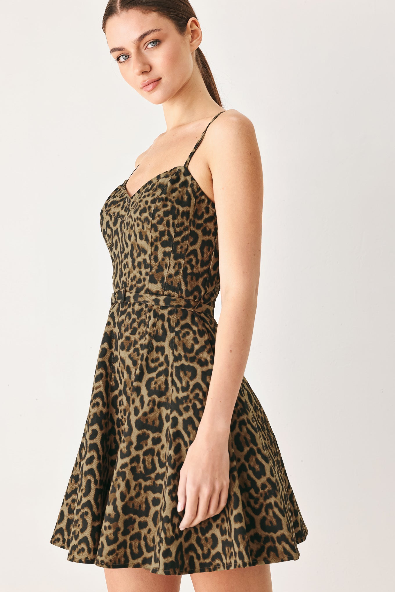 Woman wearing a leopard printed woven mini dress featuring bustier top, straps, self belt, circle skirt and back zipper closure | FREEMARKET