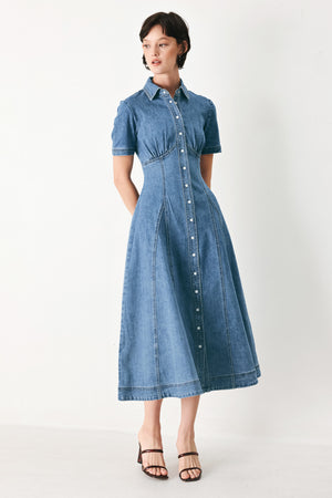 Woman wearing a blue denim midi shirt dress with front closure and circle skirt | FREEMARKET