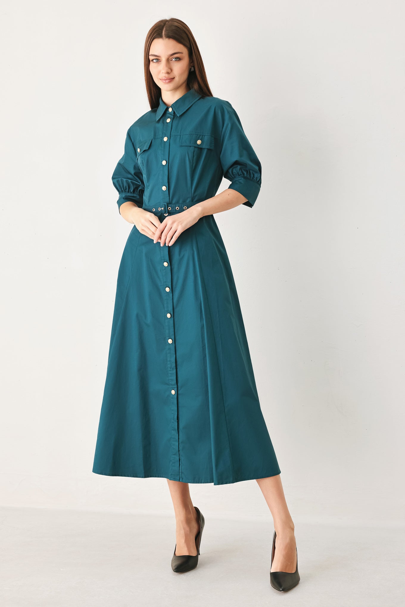 Woman wearing a teal blue midi dress featuring collar, elbow sleeve, front button down, self belt and circle skirt | FREEMARKET