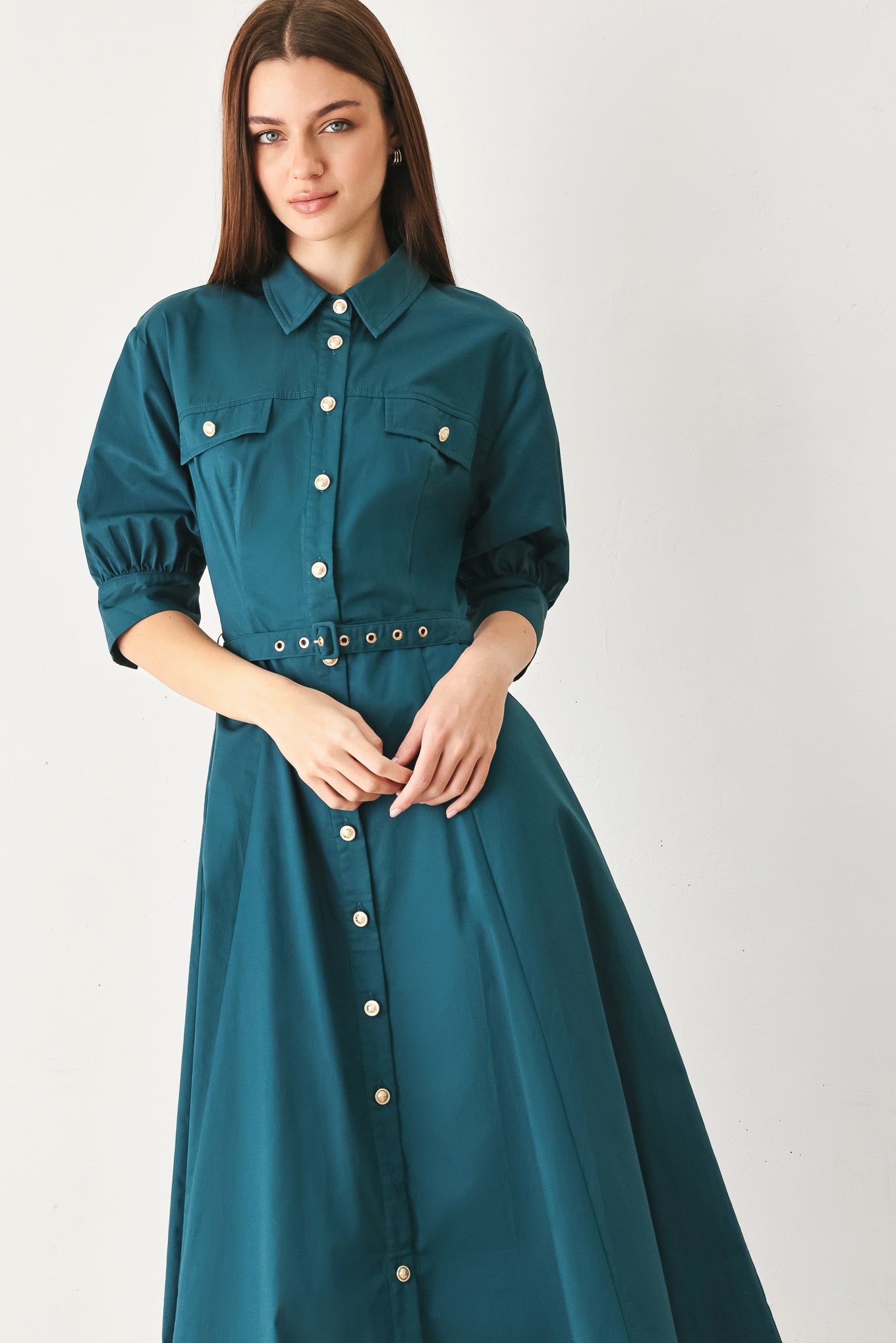 Woman wearing a teal blue midi dress featuring collar, elbow sleeve, front button down, self belt and circle skirt | FREEMARKET
