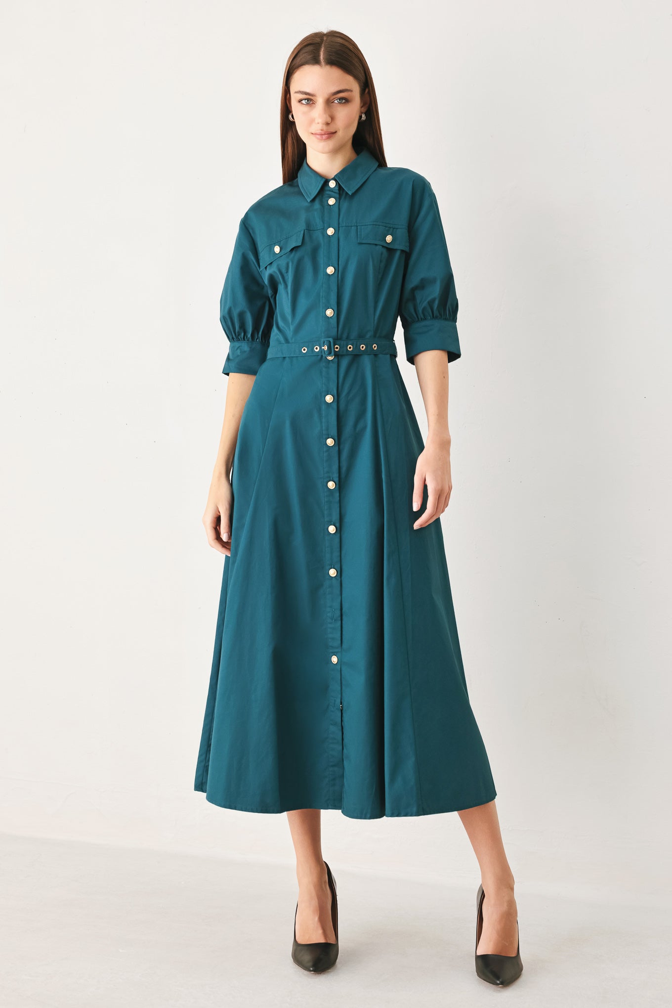 Woman wearing a teal blue midi dress featuring collar, elbow sleeve, front button down, self belt and circle skirt | FREEMARKET