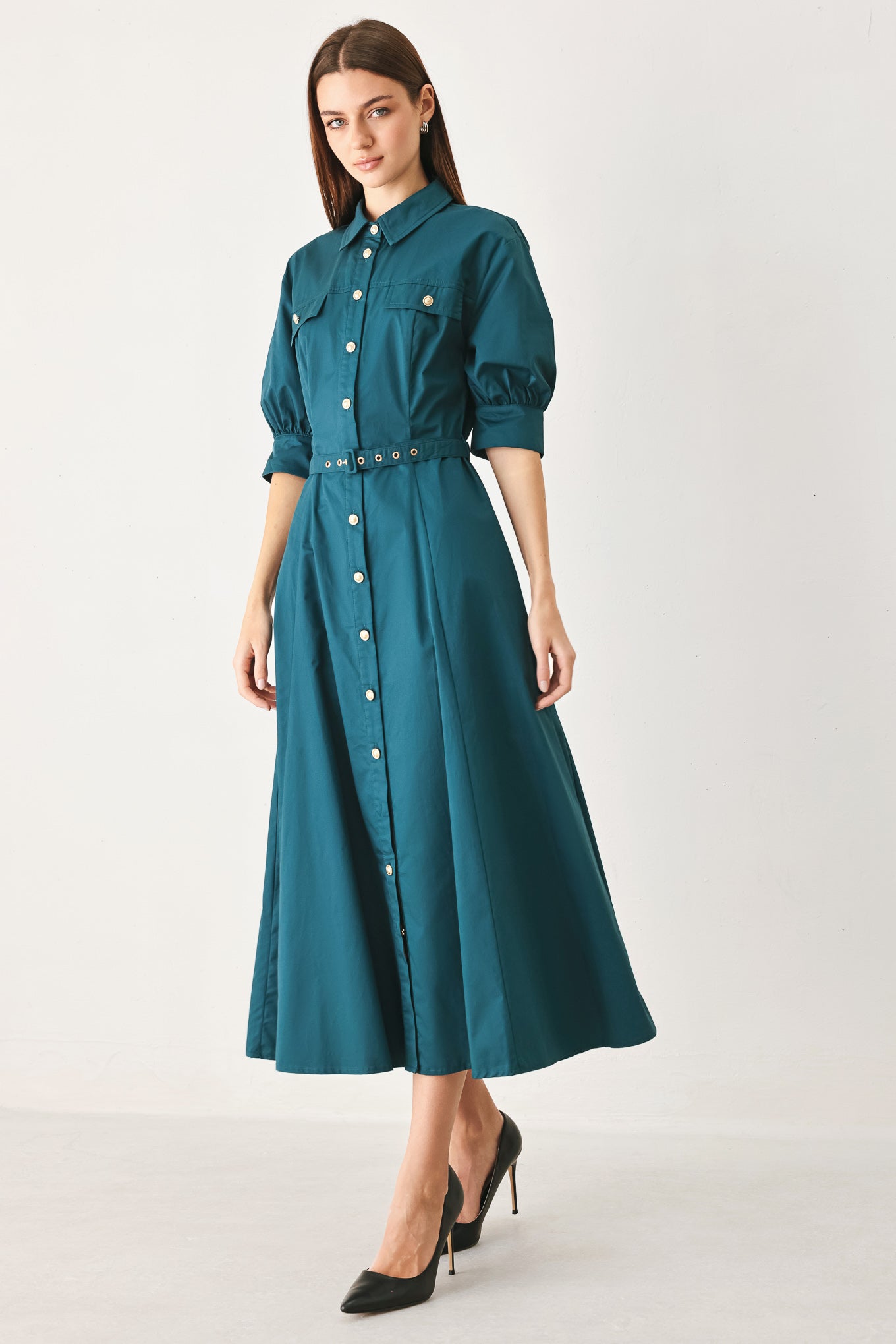 Woman wearing a teal blue midi dress featuring collar, elbow sleeve, front button down, self belt and circle skirt | FREEMARKET