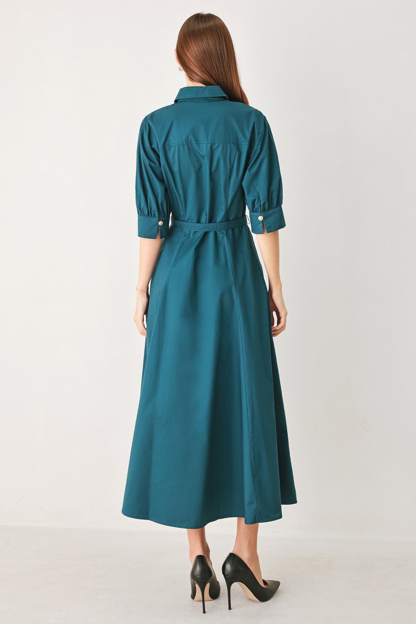 Woman wearing a teal blue midi dress featuring collar, elbow sleeve, front button down, self belt and circle skirt | FREEMARKET