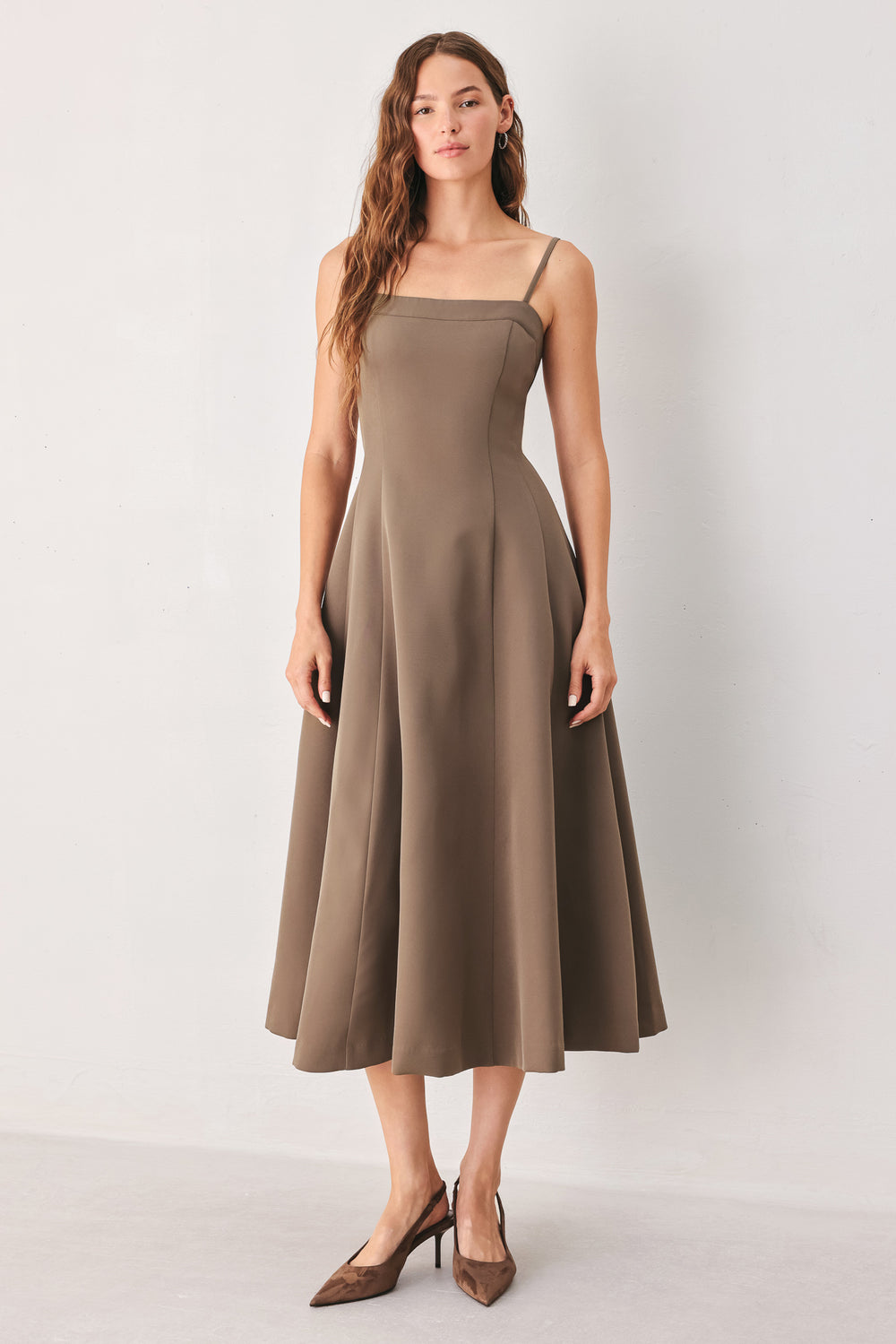 A woman wearing a sleeveless midi dress in a muted mocha-brown color | FREEMARKET
