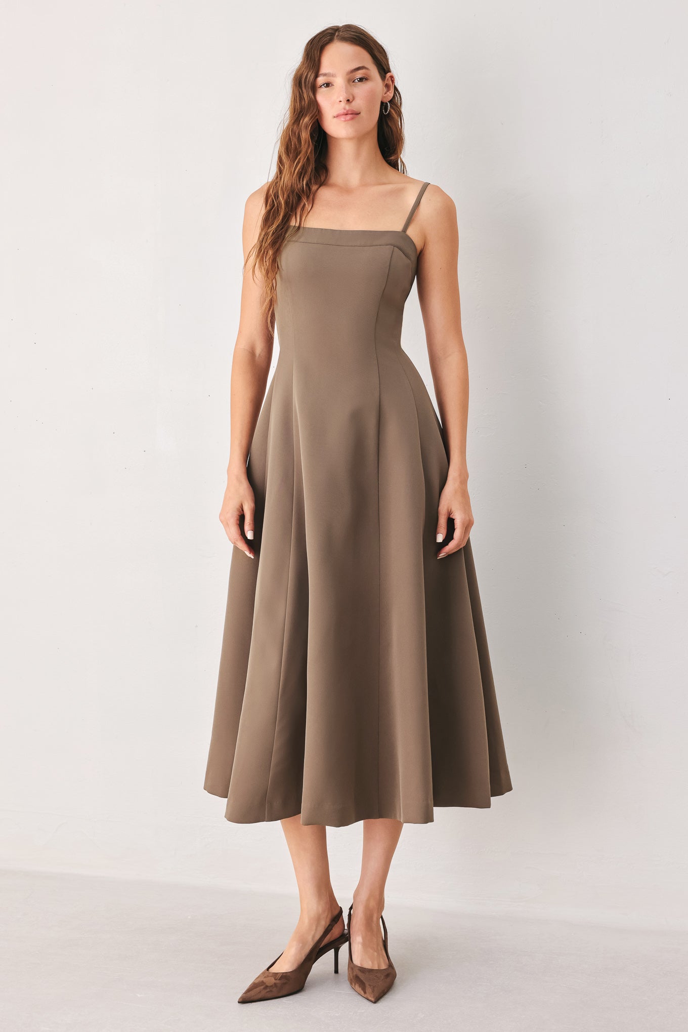 A woman wearing a sleeveless midi dress in a muted mocha-brown color | FREEMARKET