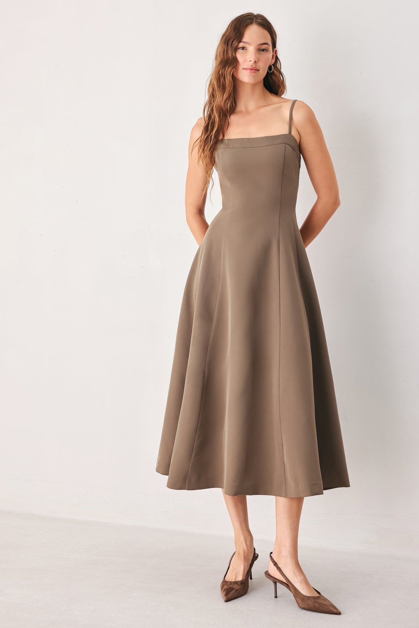 A woman wearing a sleeveless midi dress in a muted mocha-brown color | FREEMARKET