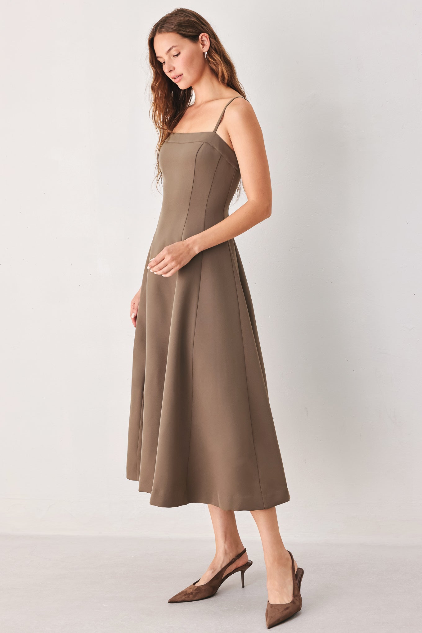 A woman wearing a sleeveless midi dress in a muted mocha-brown color | FREEMARKET