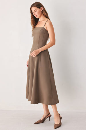 A woman wearing a sleeveless midi dress in a muted mocha-brown color | FREEMARKET