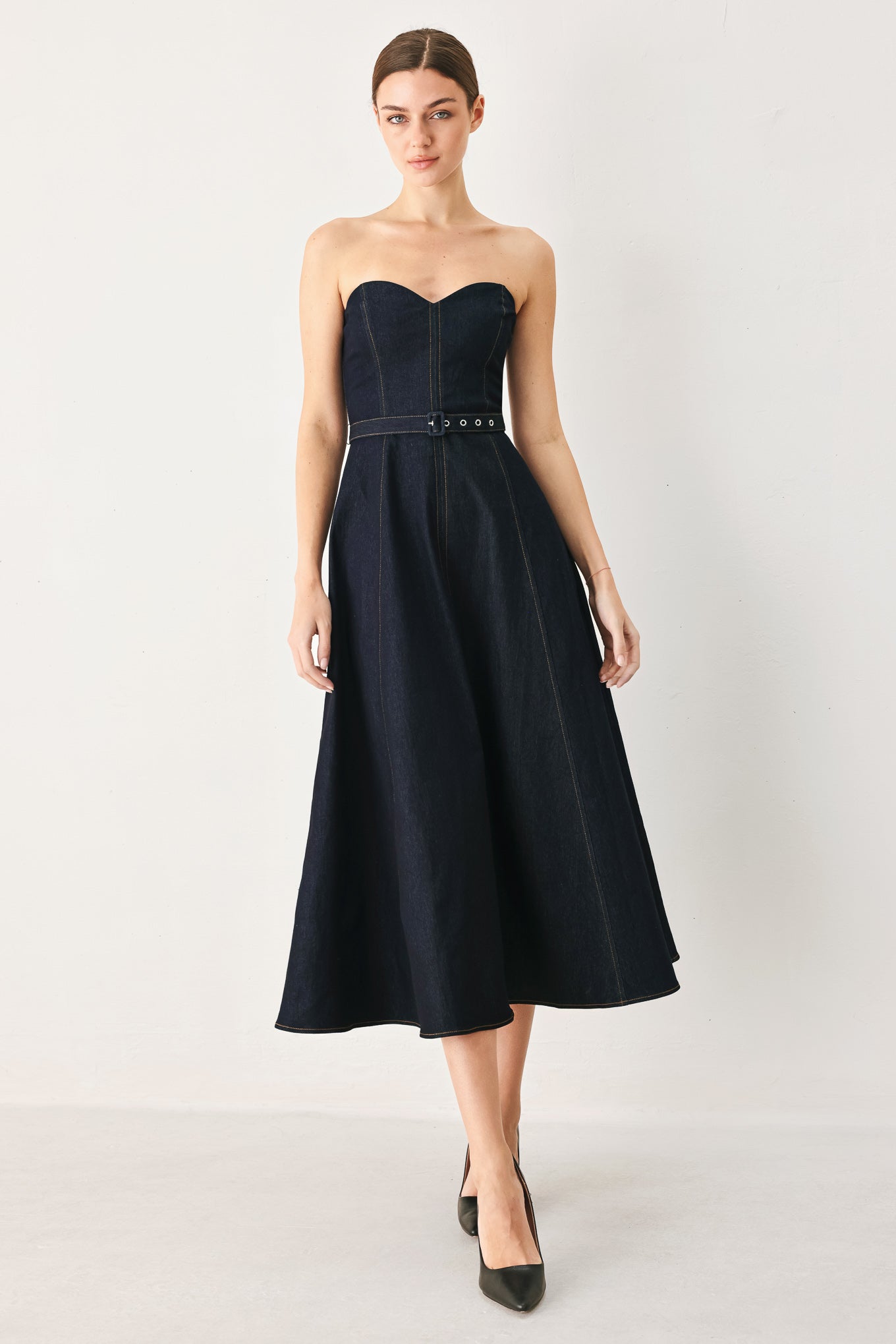 Woman wearing a black strapless dress on a white background