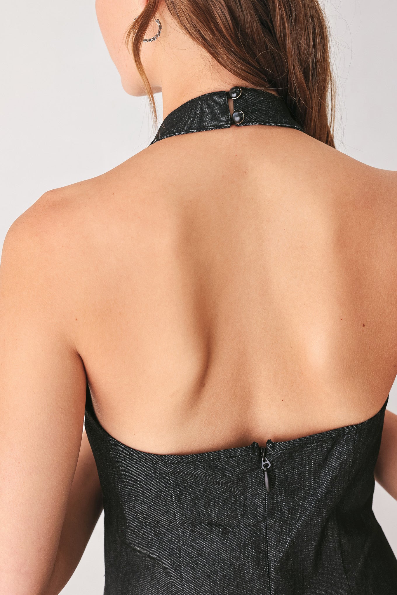 A woman modeling a sleeveless black midi dress with a high mock neck and flared skirt | FREEMARKET