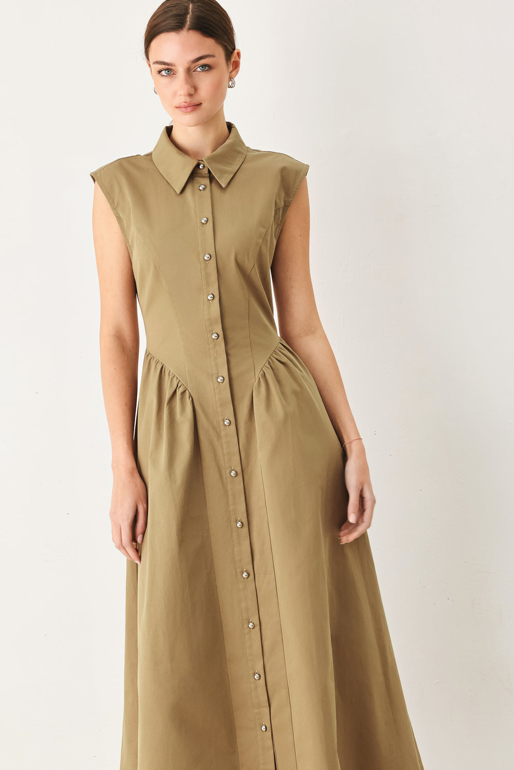 Woman wearing a sleeveless mocha woven midi dress featuring collar, button down and side shirred skirt | FREEMARKET