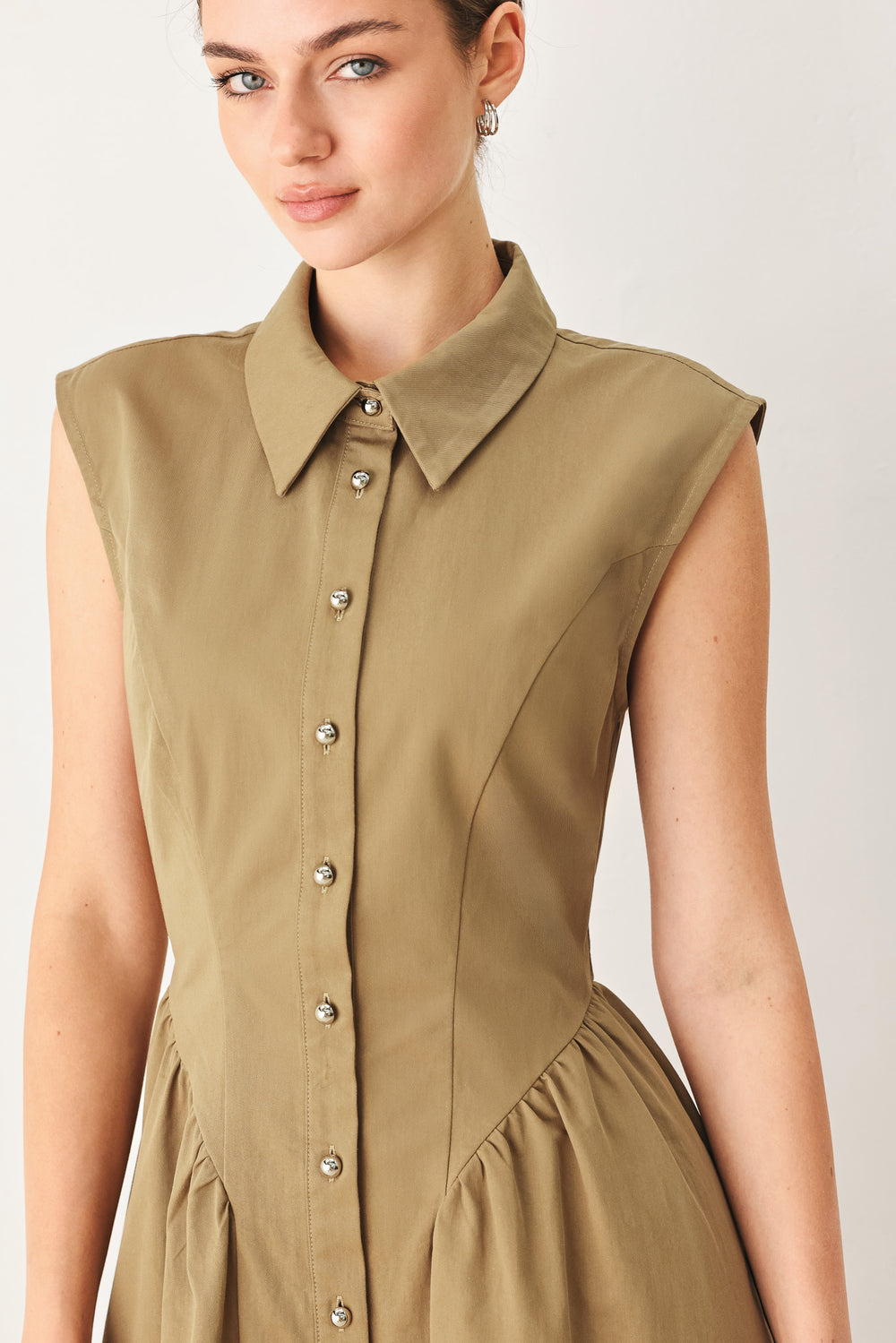 Woman wearing a sleeveless mocha woven midi dress featuring collar, button down and side shirred skirt | FREEMARKET