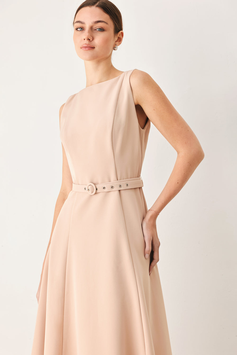 Woman wearing a sleeveless soft blush midi dress  featuring boat neckline, circle skirt, self belt and back zipper closure | FREEMARKET