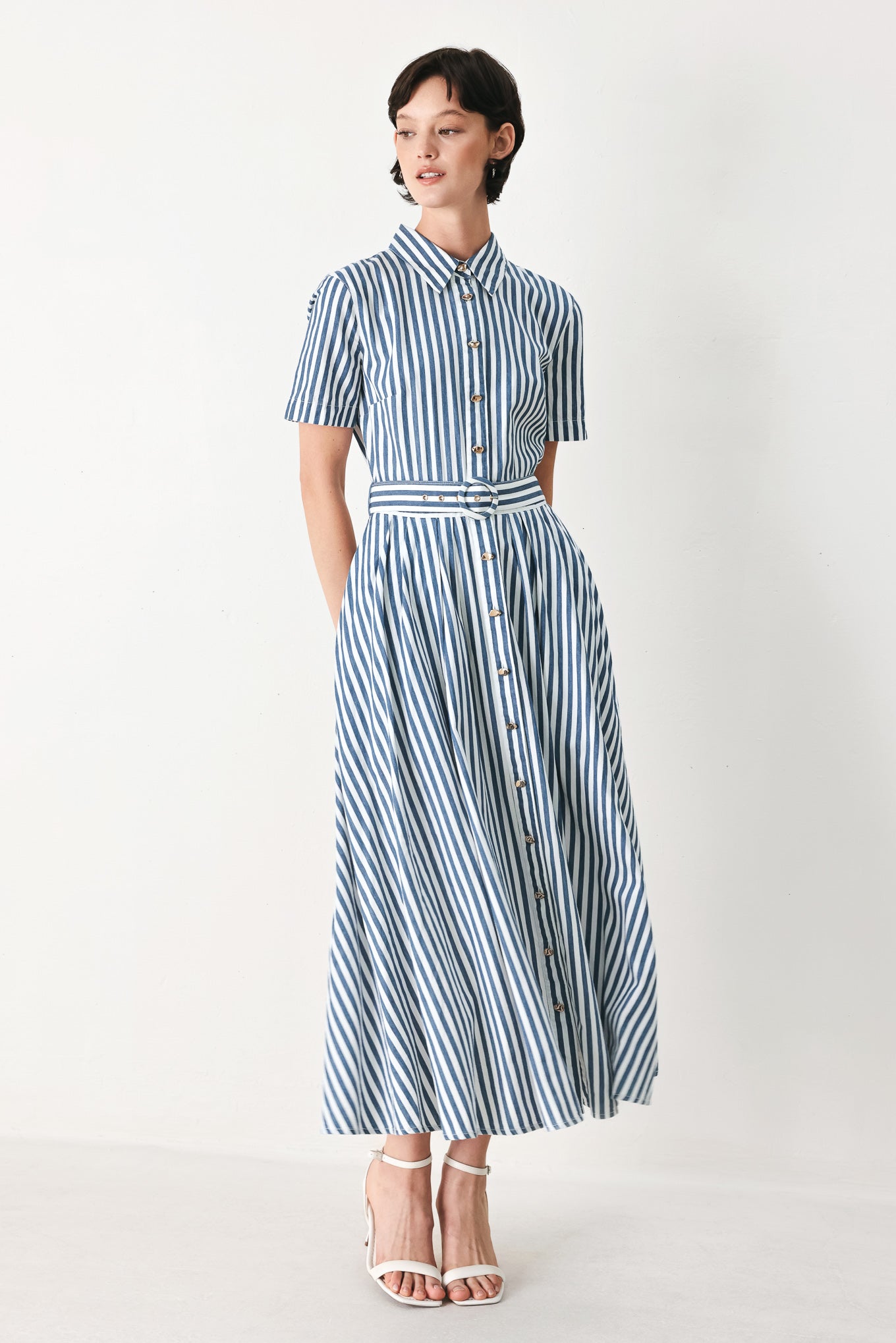 Woman wearing a denim blue and white striped midi shirt dress with self belt and full skirt | FREEMARKET