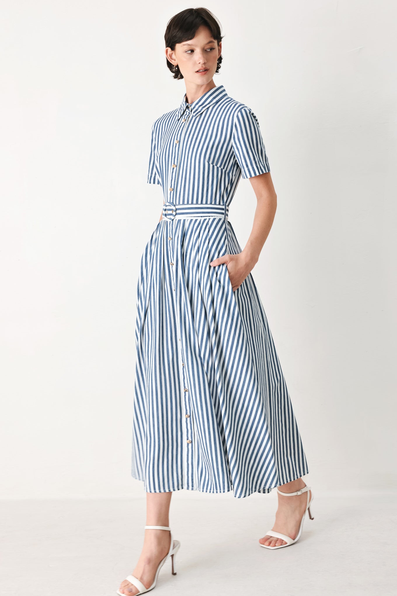 Woman wearing a denim blue and white striped midi shirt dress with self belt and full skirt | FREEMARKET