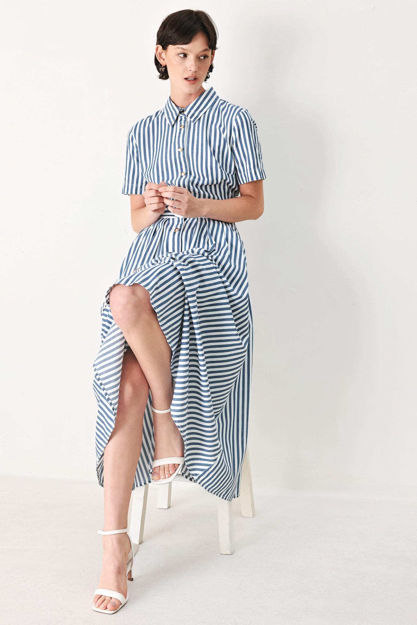 Woman wearing a denim blue and white striped midi shirt dress with self belt and full skirt | FREEMARKET