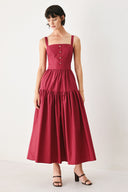 Woman wearing a burgundy red midi dress featuring straight neckline, straps, front button detail, single tier and back zipper | FREEMARKET