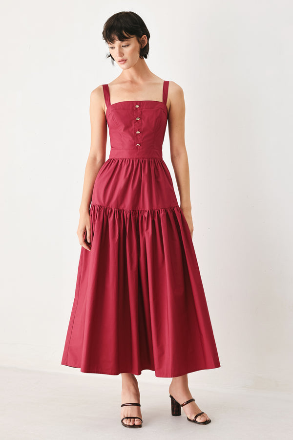 Woman wearing a burgundy red midi dress featuring straight neckline, straps, front button detail, single tier and back zipper | FREEMARKET