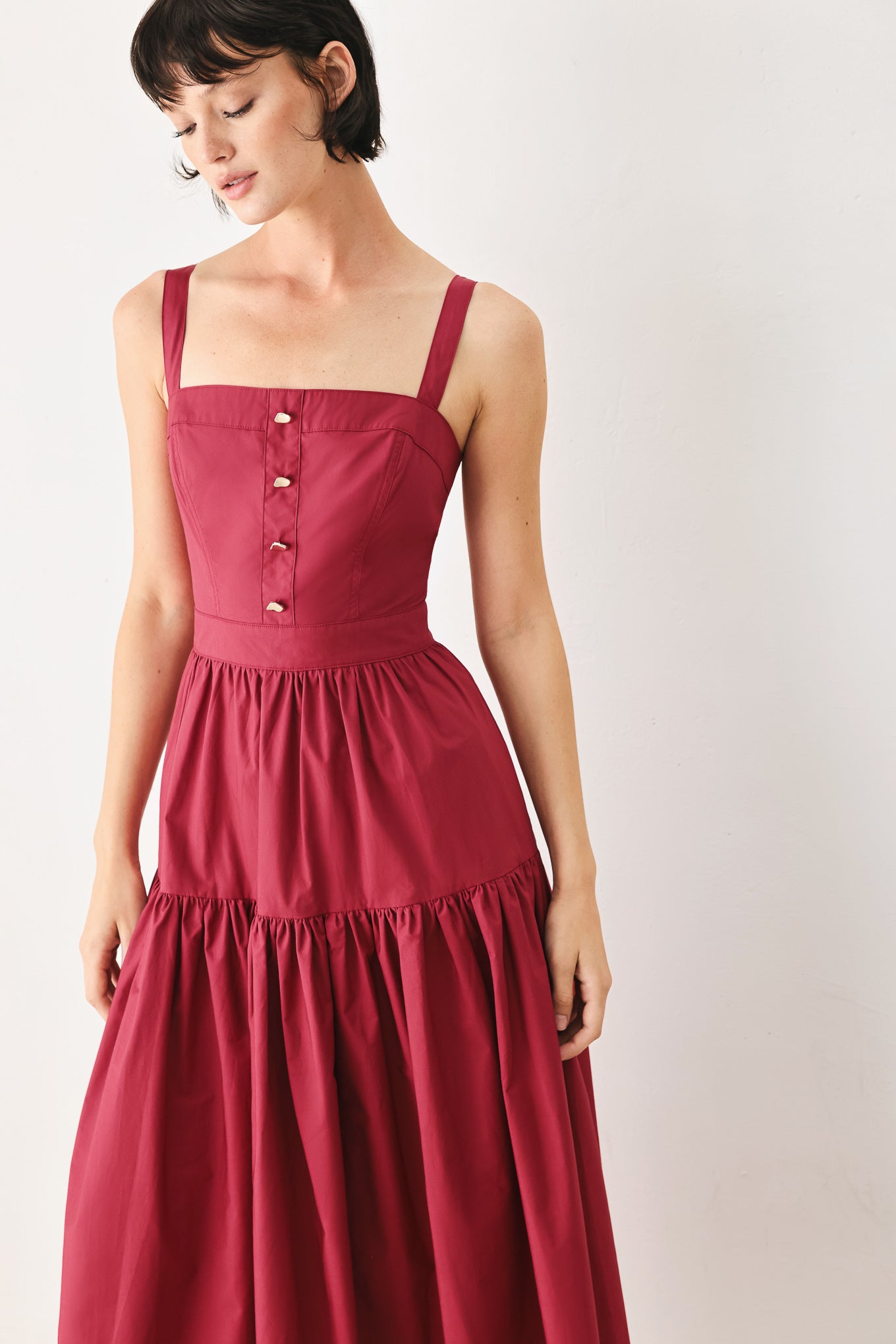 Woman wearing a burgundy red midi dress featuring straight neckline, straps, front button detail, single tier and back zipper | FREEMARKET