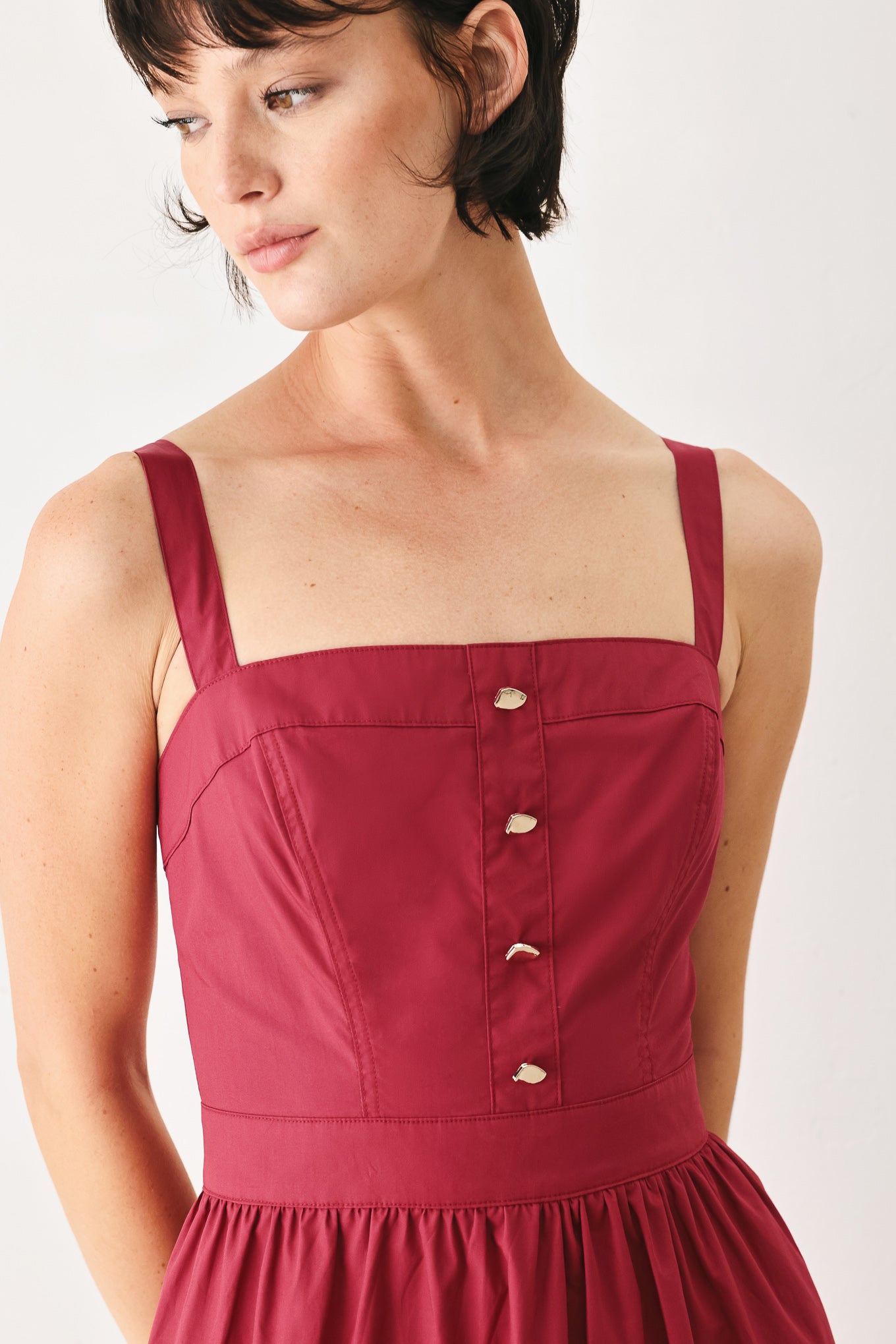 Woman wearing a burgundy red midi dress featuring straight neckline, straps, front button detail, single tier and back zipper | FREEMARKET