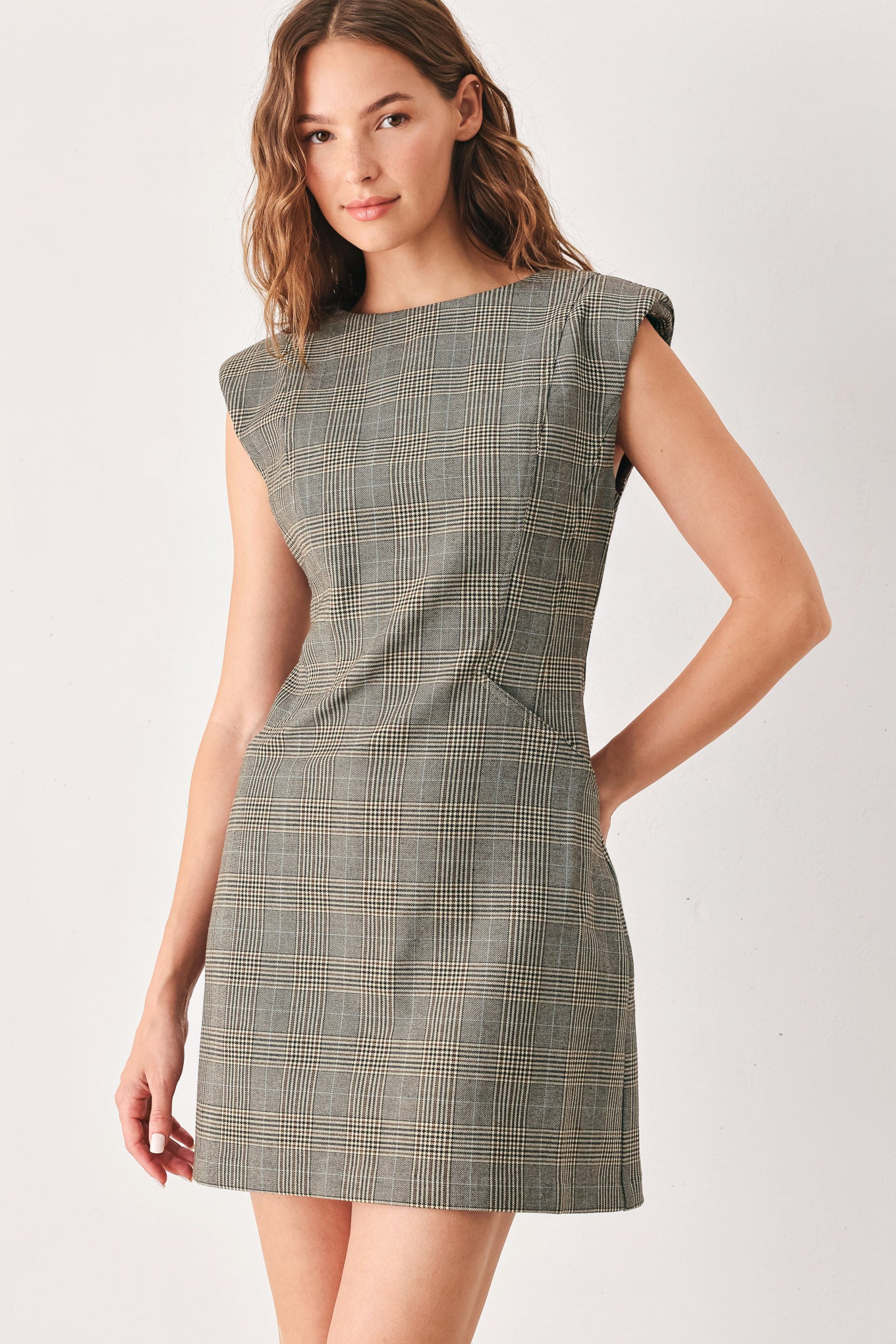 A woman wearing a sleeveless, min gray plaid dress with structured shoulders | FREEMARKET