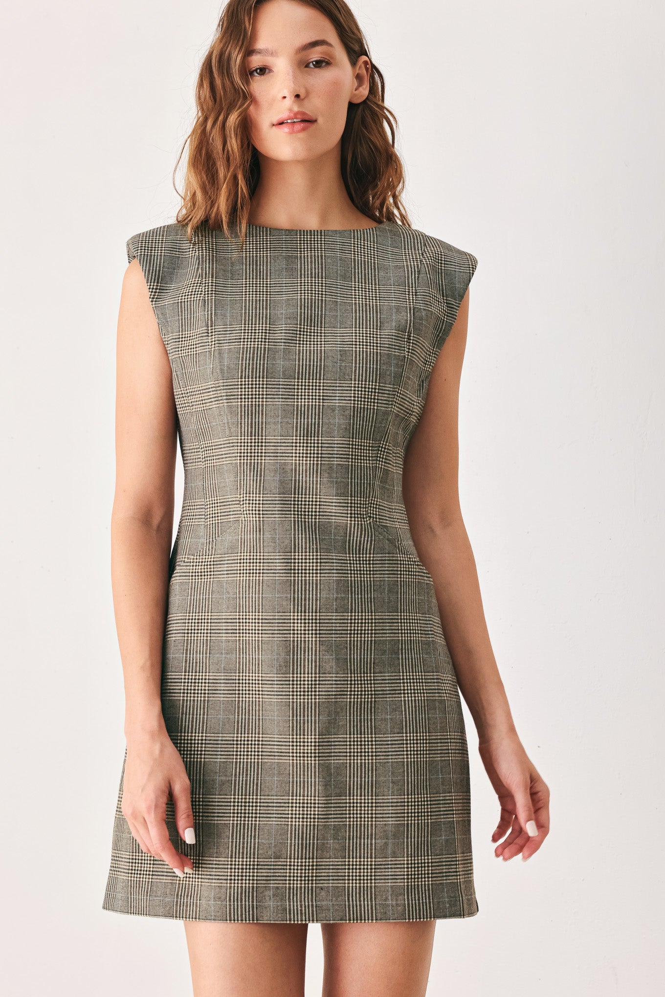 A woman wearing a sleeveless, min gray plaid dress with structured shoulders | FREEMARKET