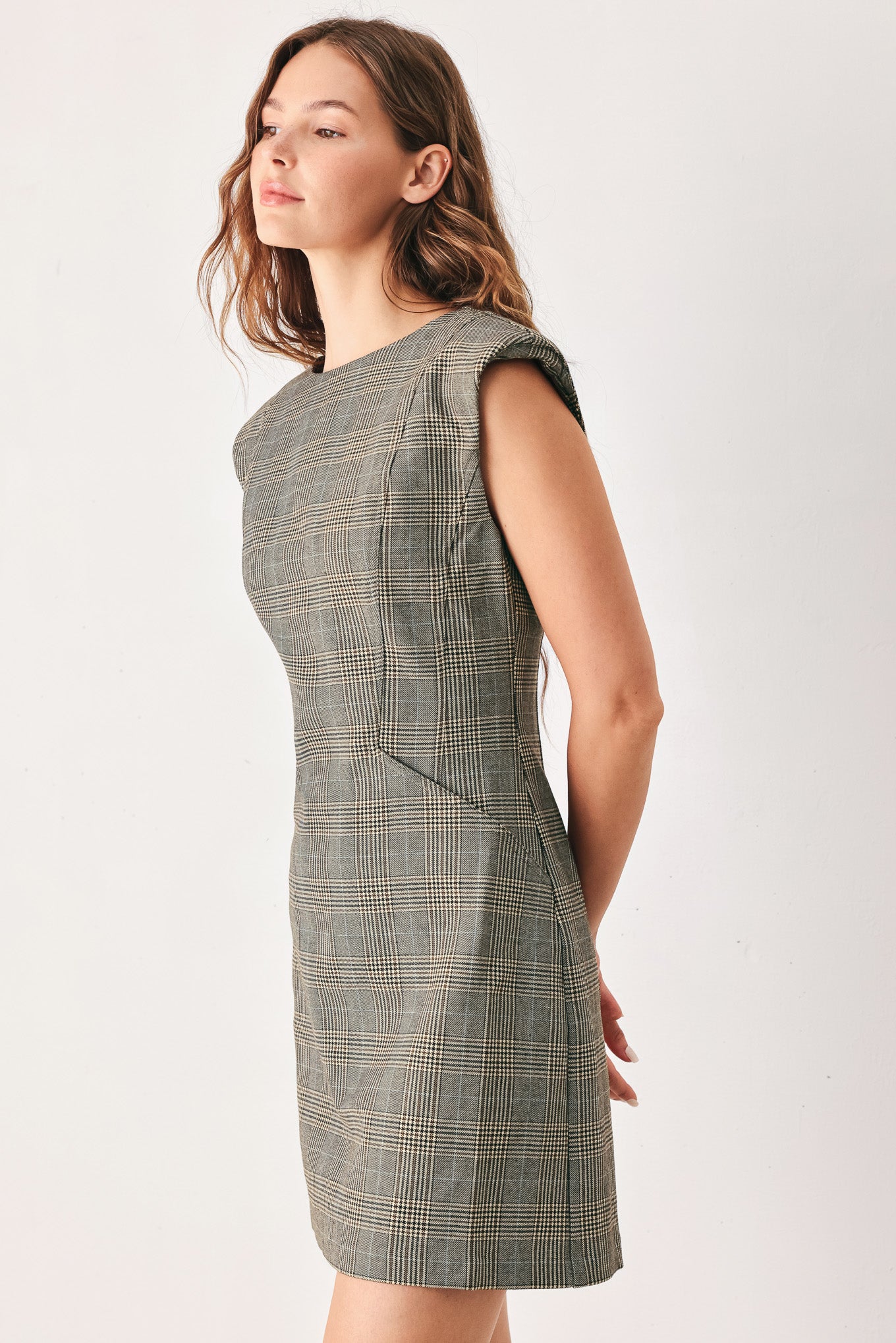 A woman wearing a sleeveless, min gray plaid dress with structured shoulders | FREEMARKET