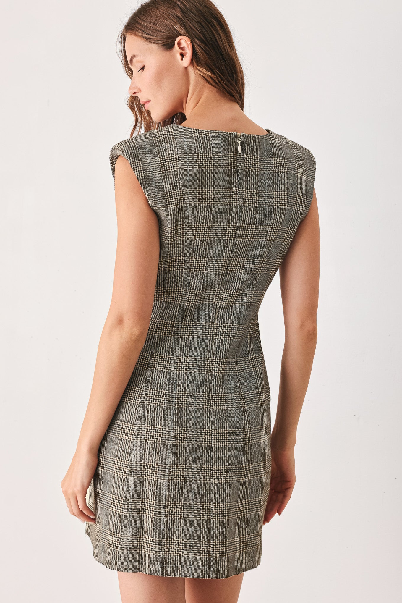 A woman wearing a sleeveless, min gray plaid dress with structured shoulders | FREEMARKET