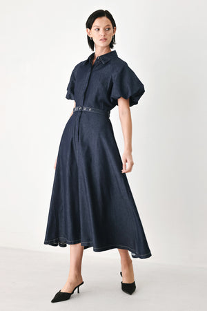 A woman models a dark indigo denim midi shirt dress with short puff sleeves, a pointed collar, and a matching dark belt | FREEMARKET