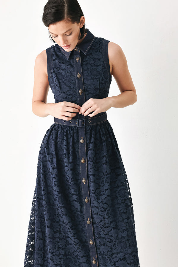 A woman modeling a sleeveless navy midi dress with a lace overlay, button-front bodice, and matching belt | FREEMARKET