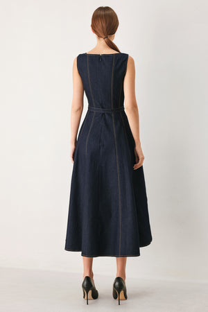 Woman wearing a dark denim sleeveless midi dress featuring wide neckline, self belt, full circle skirt and back zipper closure | FREEMARKET