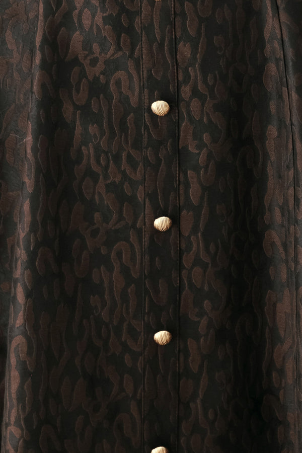 A woman modeling a black midi dress with a textured jacquard leopard pattern, featuring thin spaghetti straps, a sweetheart neckline, a button-down front, and side pockets | FREEMARKET