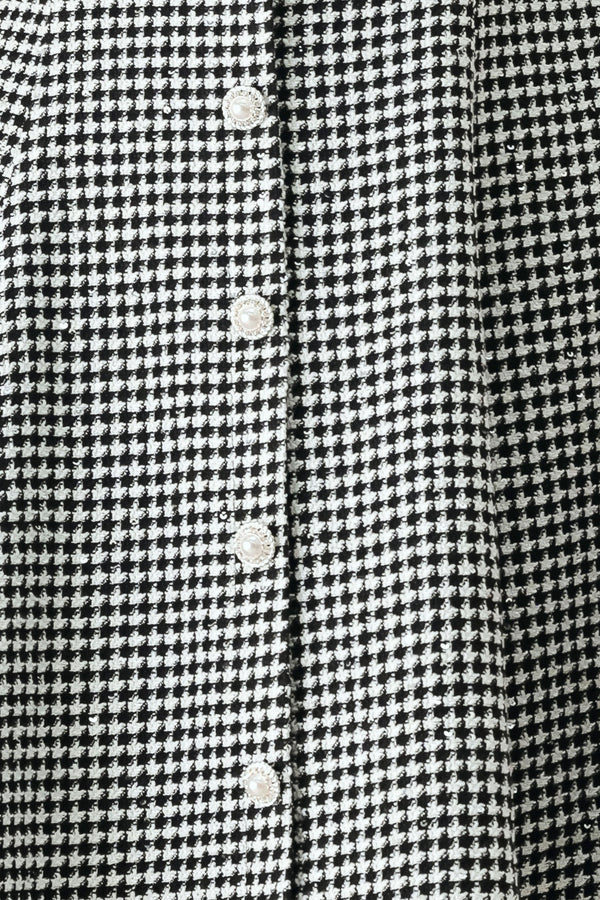 Woman wearing a black and white houndstooth sleeveless mini dress with buttons along the front and sequins | FREEMARKET