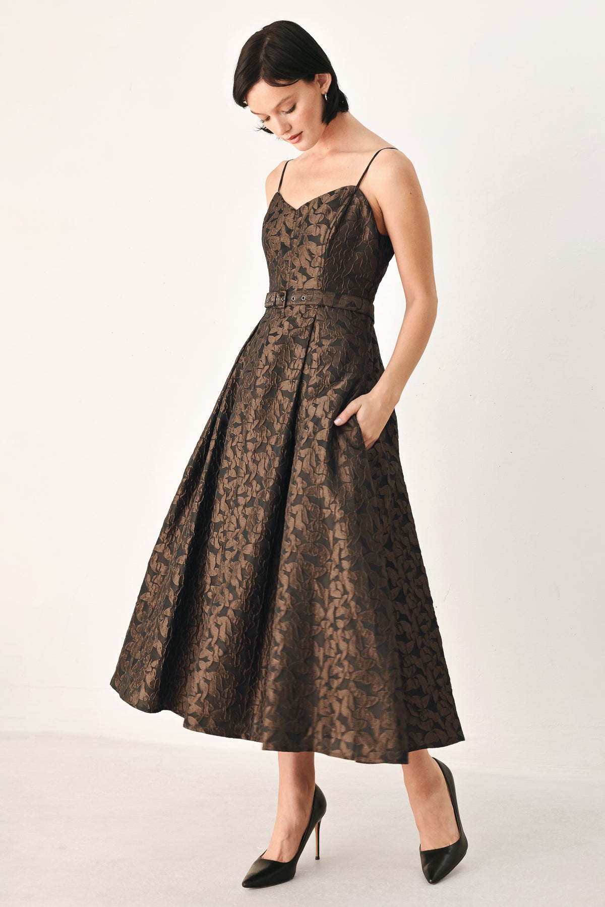 A woman modeling a sleeveless midi dress with thin straps, a sweetheart neckline, and a fitted waist. The dress has an allover dark brown and black floral jacquard pattern | FREEMARKET