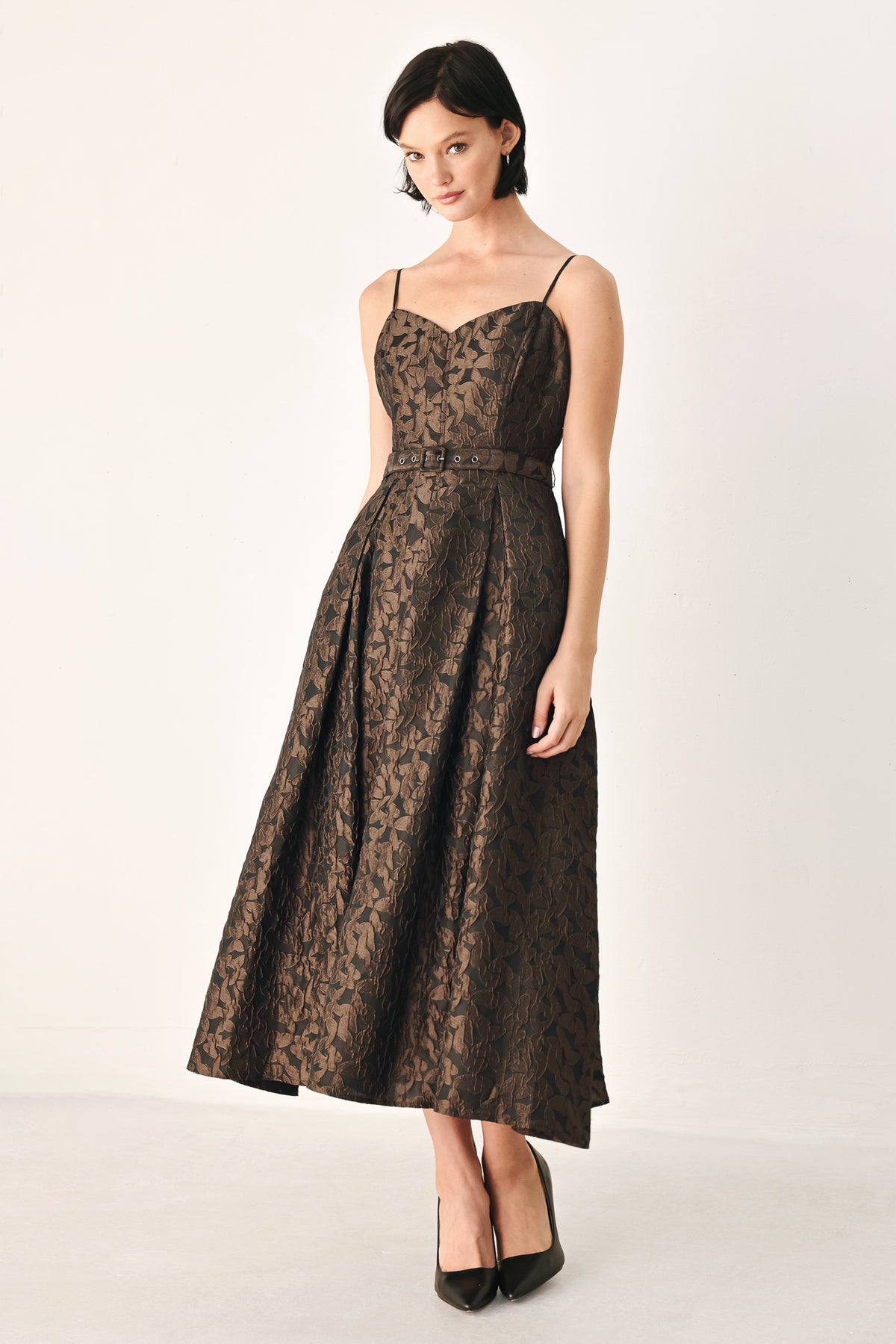 A woman modeling a sleeveless midi dress with thin straps, a sweetheart neckline, and a fitted waist. The dress has an allover dark brown and black floral jacquard pattern | FREEMARKET