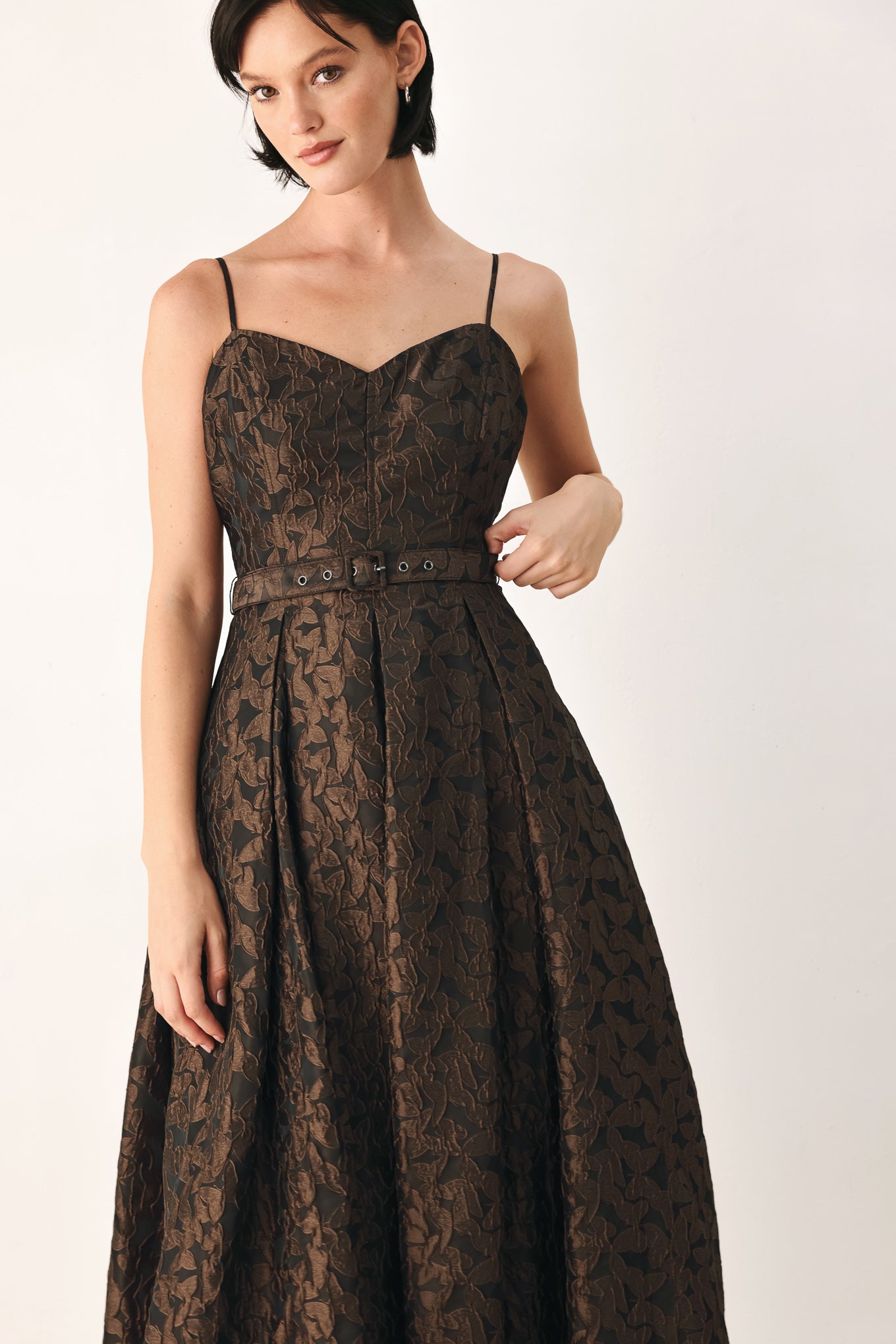 A woman modeling a sleeveless midi dress with thin straps, a sweetheart neckline, and a fitted waist. The dress has an allover dark brown and black floral jacquard pattern | FREEMARKET