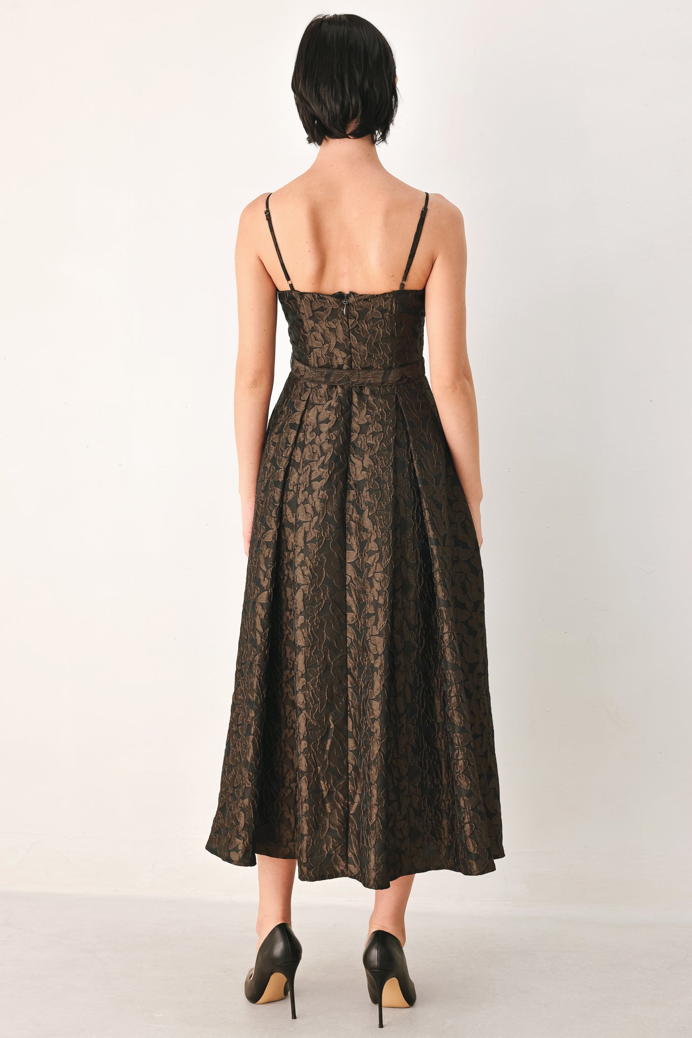 A woman modeling a sleeveless midi dress with thin straps, a sweetheart neckline, and a fitted waist. The dress has an allover dark brown and black floral jacquard pattern | FREEMARKET