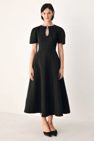 A woman modeling a black midi dress with short puff sleeves, a keyhole neckline with rhinestone embellishments, and a flared skirt | FREEMARKET