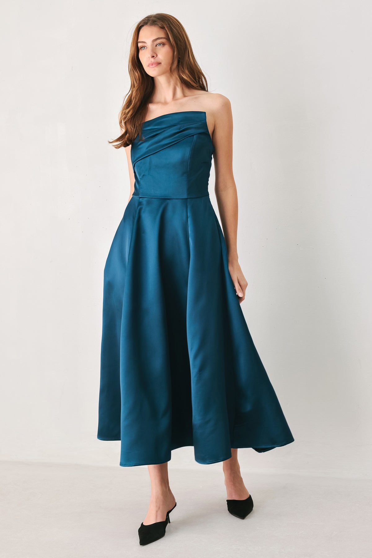 Woman wearing a strapless satin-like teal midi dress with asymmetrical neckline | FREEMARKET