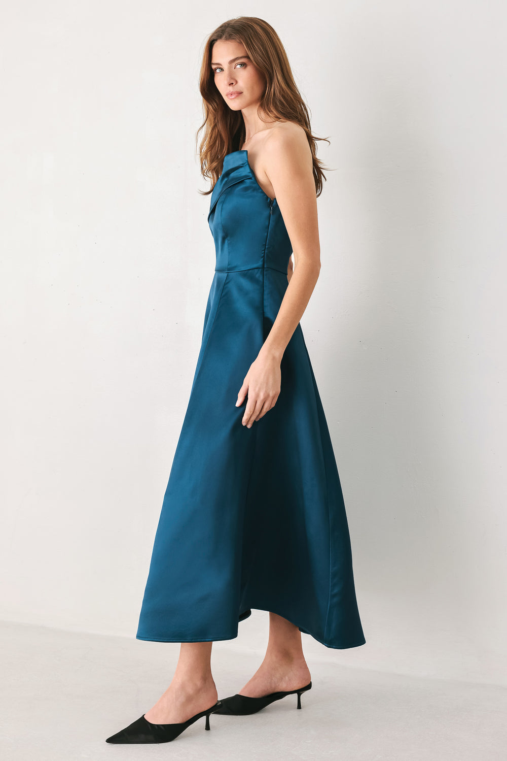 Woman wearing a strapless satin-like teal midi dress with asymmetrical neckline | FREEMARKET