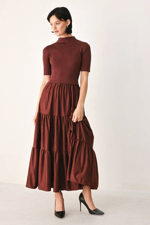 A woman modeling a rust-brown tiered midi dress with short sleeves and a mock neck | FREEMARKET