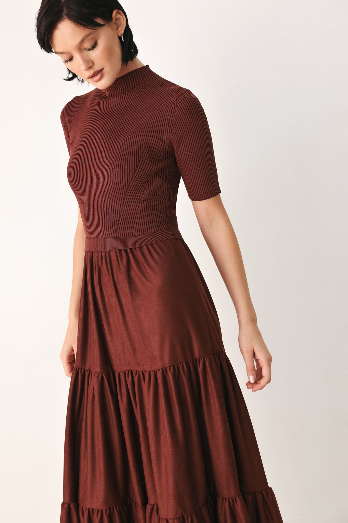 A woman modeling a rust-brown tiered midi dress with short sleeves and a mock neck | FREEMARKET