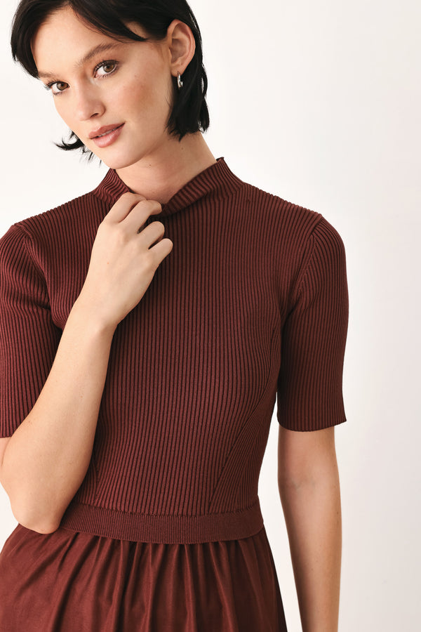 A woman modeling a rust-brown tiered midi dress with short sleeves and a mock neck | FREEMARKET
