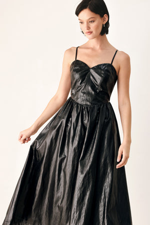 A woman modeling a black faux leather midi dress with a shiny, textured finish, featuring thin spaghetti straps, a sweetheart neckline, a gathered corset-style bodice, and a flared skirt | FREEMARKET
