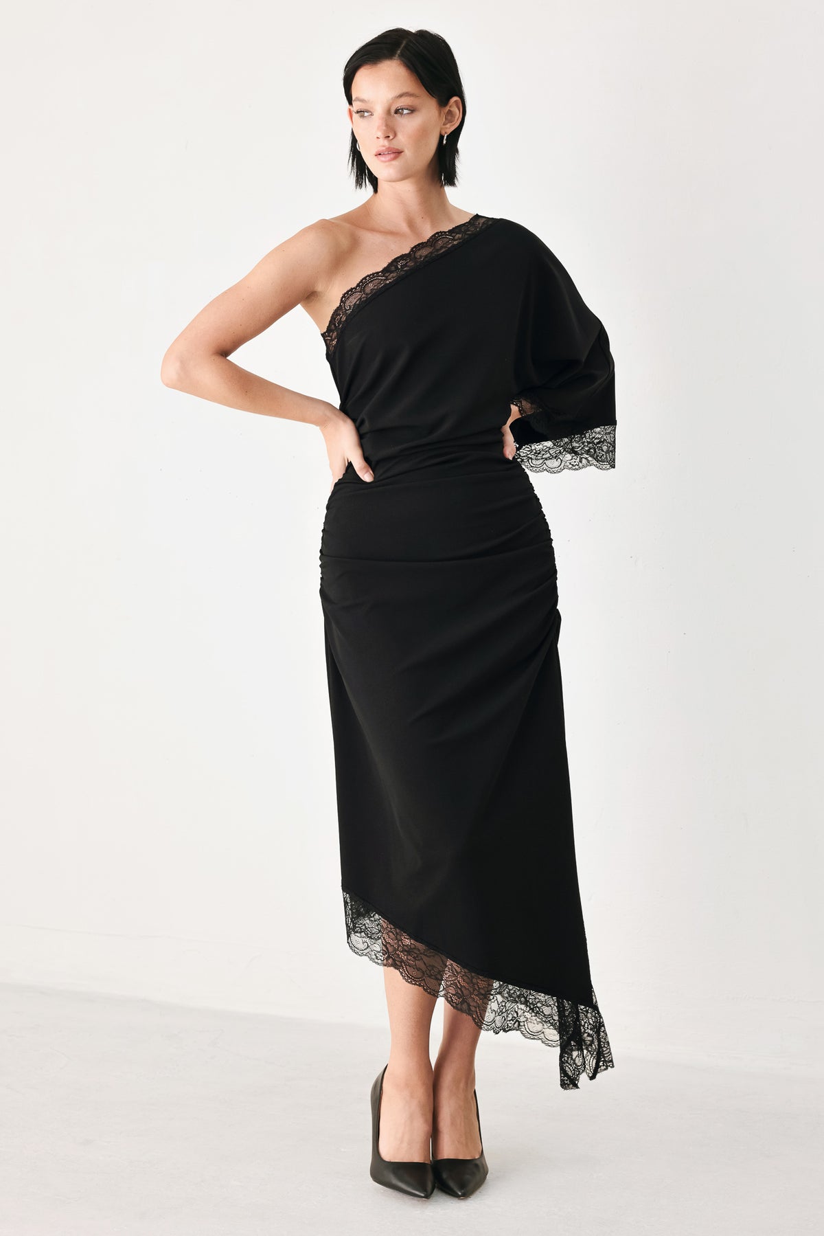 A model wearing a black one-shoulder midi dress with lace trim on the sleeve and hem | FREEMARKET