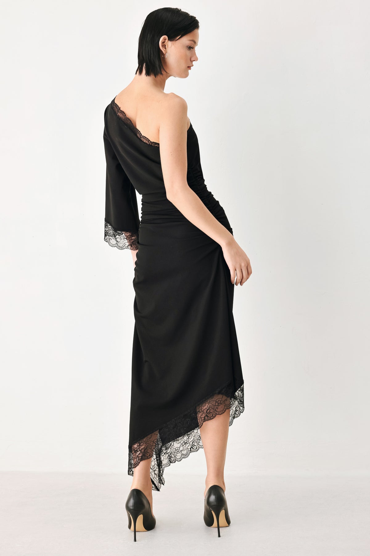 A model wearing a black one-shoulder midi dress with lace trim on the sleeve and hem | FREEMARKET