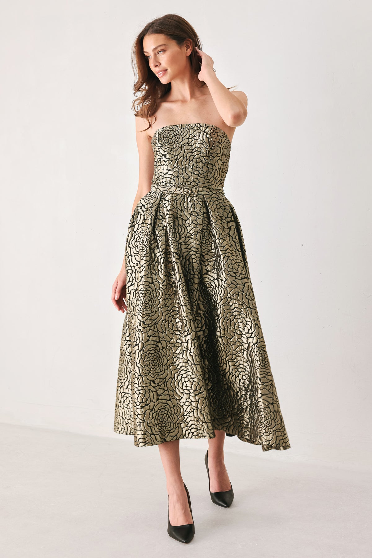A woman models a strapless midi dress with a black and metallic gold floral pattern | FREEMARKET