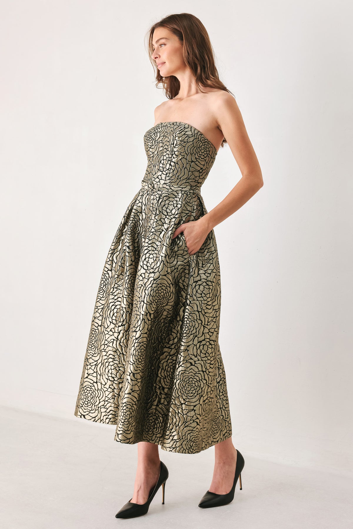 A woman models a strapless midi dress with a black and metallic gold floral pattern | FREEMARKET