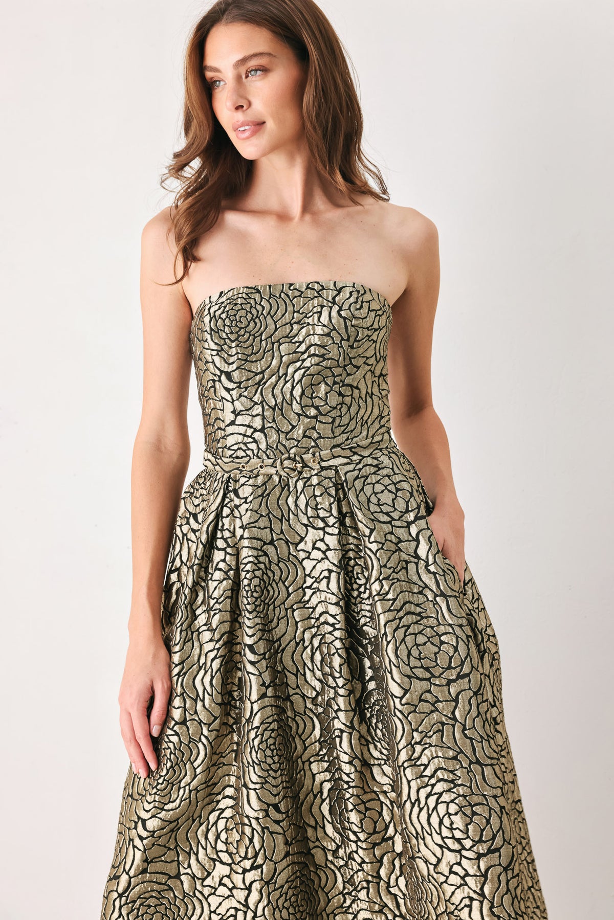A woman models a strapless midi dress with a black and metallic gold floral pattern | FREEMARKET