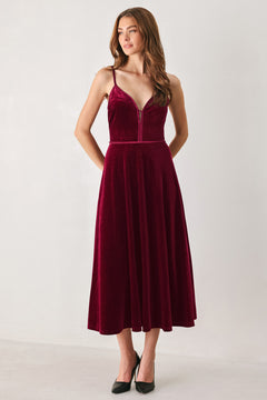 Woman wearing a sleeveless red burgundy velvet midi dress with a slight plunge | FREEMARKET
